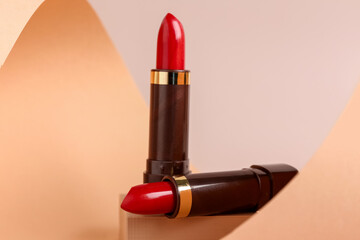 Decorative podium with beautiful red lipsticks on beige background