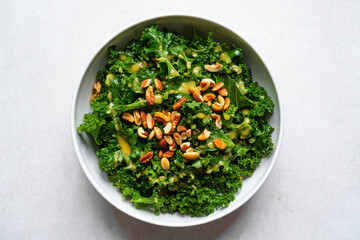 Healthy chopped kale salad with toasted nuts and dressing