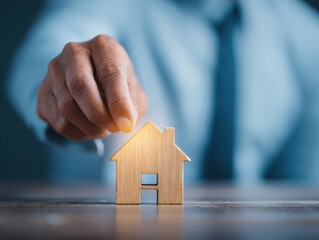 Securing a stable future in Real Estate Investment, Businessman Customer Picks a Wooden House Model for Financial Security and Growth.