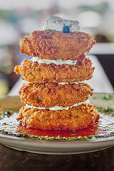 stack of fried green tomatoes with mozzarella cheese, basil pesto, and marinara sauce