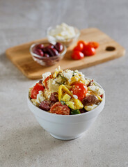 Greek chicken salad made with tomato, artichokes, olives, and feta cheese