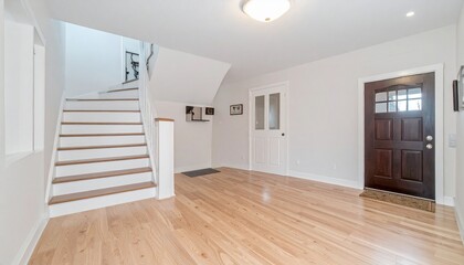Fototapeta premium Bright Entryway with Hardwood Floors, Staircase, and Doors