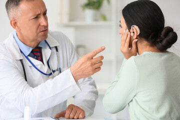 Young woman with hearing aid visiting doctor in clinic