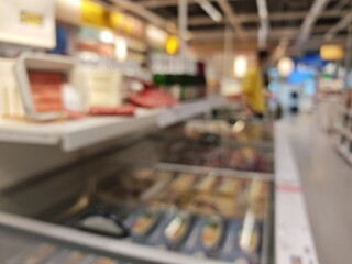 Abstract bokeh image of a brightly lit retail space with blurred movement.