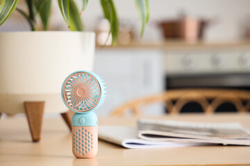 Mini fan on table in kitchen, closeup