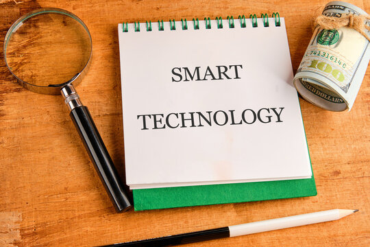 The concept of technology and development. Phrase, words, text SMART TECHNOLOGY in a notebook on an old background, top view