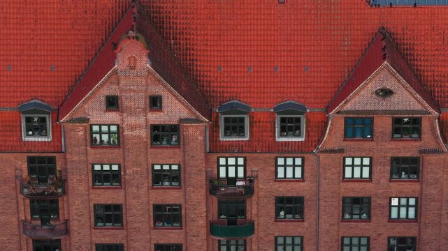 Aerial drone view of a traditional red-brick residential building in Amagerbro, Copenhagen, Denmark, with steep tiled roofs and Scandinavian architecture