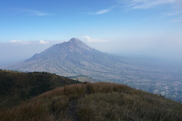 Fototapeta premium The savannah on Mount Merbabu with Mount Merapi in the background. Central Java, Indonesia