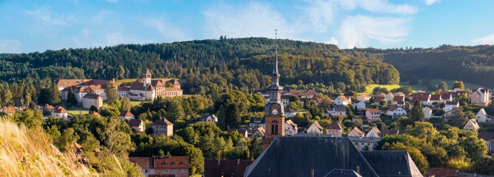 Bitche, Grand Est, Frankreich &ndash; Panoramablick im Sommer von der Citadelle de Bitche auf die Stadt im Gegenlicht, gr&uuml;ne H&uuml;gel, blauer Himmel, sonnig, Gef&uuml;hl von Freiheit und Reisen.