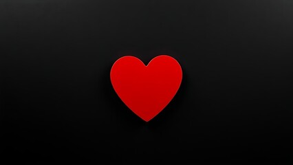 A striking red heart on a textured black background, representing deep emotions and minimalist beauty.