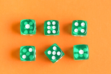 Green game dices on orange background
