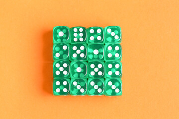 Green game dices on orange background
