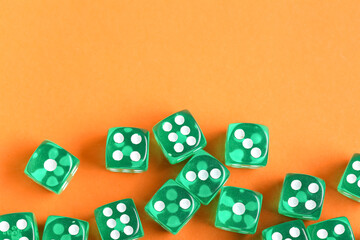 Green game dices on orange background
