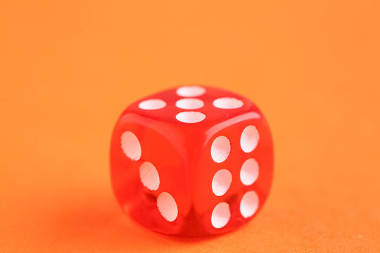 Red game dice on orange background