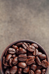 Freshly Roasted Coffee Beans in a Dark Bowl on a Neutral Background