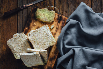Freshly Baked Bread Slices on Wooden Board with Kitchen Cloth