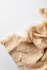 Soft beige fabric with frayed edges on a light background