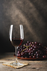 Elegant Red Wine Glass with Fresh Grapes on Rustic Wooden Table