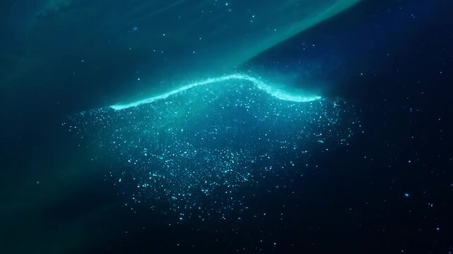 Glowing particles coalesce into a vibrant, abstract, organic shape. This ethereal blue light forms a dynamic, evolving, luminous entity.