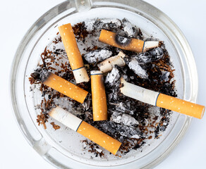 Cigarette Butts and Ashes in a Clear Ashtray on White Background