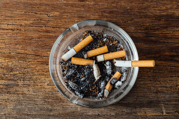 Ashtray with Used Cigarettes and Ashes on Wooden Table Surface
