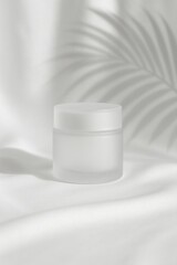 Frosted glass jar with white lid on silk background