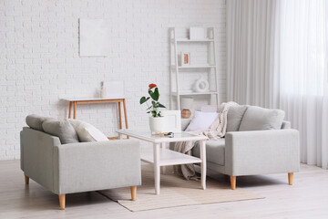 Interior of living room with sofas and Anthurium flower on glass table