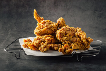 Crispy Fried Chicken Piled on a Wire Cooling Rack with Paper