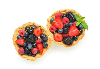 Sweet tartlets with different fresh berries and mint on white background
