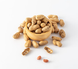 Bowl of raw peanuts on a white background in a casual arrangement