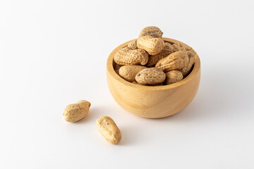 Raw Unshelled Peanuts in Wooden Bowl on White Background