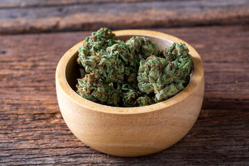Close-Up of Freshly Harvested Green Cannabis Buds in Wooden Bowl