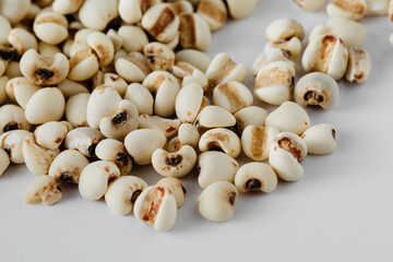 Close-Up of Raw White Bean Seeds on White Surface for Culinary Use