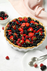 Sweet tart with different fresh berries on white background, closeup