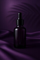 Luxury black dropper bottle on purple silk fabric, modern skincare serum packaging mockup.
