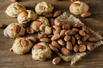 Freshly Baked Cookies with Almonds and Raw Almonds on Rustic Table