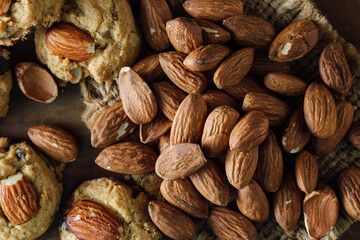 Freshly Baked Cookies with Almonds and Raw Whole Almonds on Wood