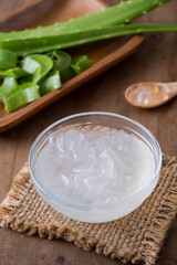 Aloe Vera Gel in Bowl with Fresh Leaves on Rustic Wooden Table