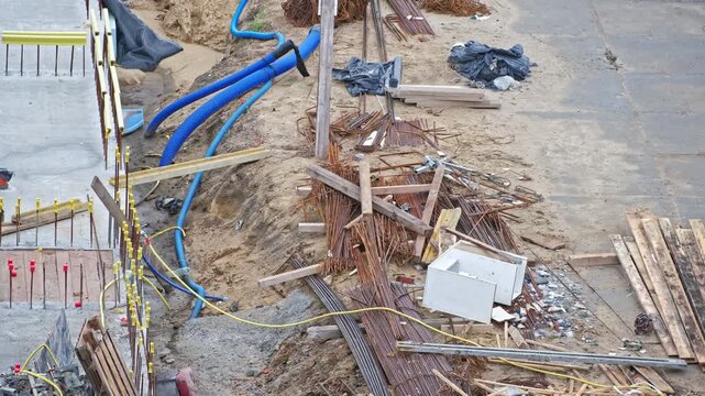 Messy Construction Site of Office and Residential Building with Rebar Reinforcement and Precast Concrete Slabs Corrugated Pipes and Wooden Formwork