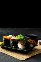 Fresh Sushi Platter with Various Rolls on a Black Background