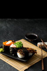 Elegant Plate of Sushi with Assorted Toppings and Dipping Sauce