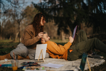 A couple enjoys a relaxing painting session outdoors, fostering creativity and connection in nature.