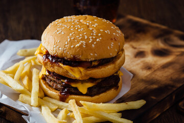 Juicy Cheeseburger with Fries on Wooden Table Surface
