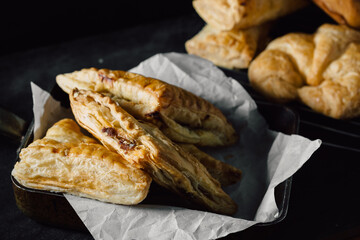 Freshly Baked Pastries with Flaky Layers on Dark Background