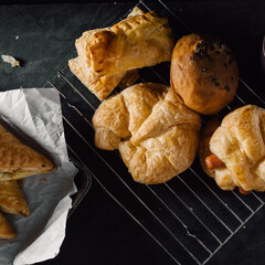 Freshly Baked Pastries and Bread on Dark Table Surface