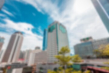 An abstract bokeh background with blurry buildings and blue sky in a shopping mall in Shenzhen,...
