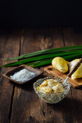 Fresh Coconut Cream with Salt and Yellow Fruits on Rustic Wood