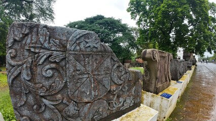  Historic gravestone with intricate carvings and engravings displayed in the open area of the Chapel of St. Catherine, Old Goa
