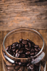 Coffee Beans in Clear Glass Jar on Wooden Background