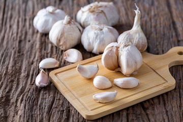 Fresh Garlic Bulbs and Cloves on Wooden Cutting Board Background